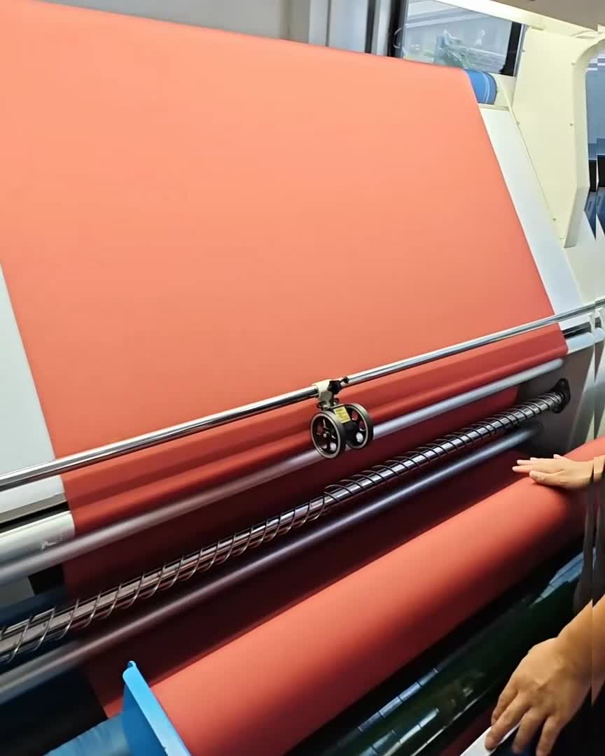 An operator working beside fabric inspection equipment